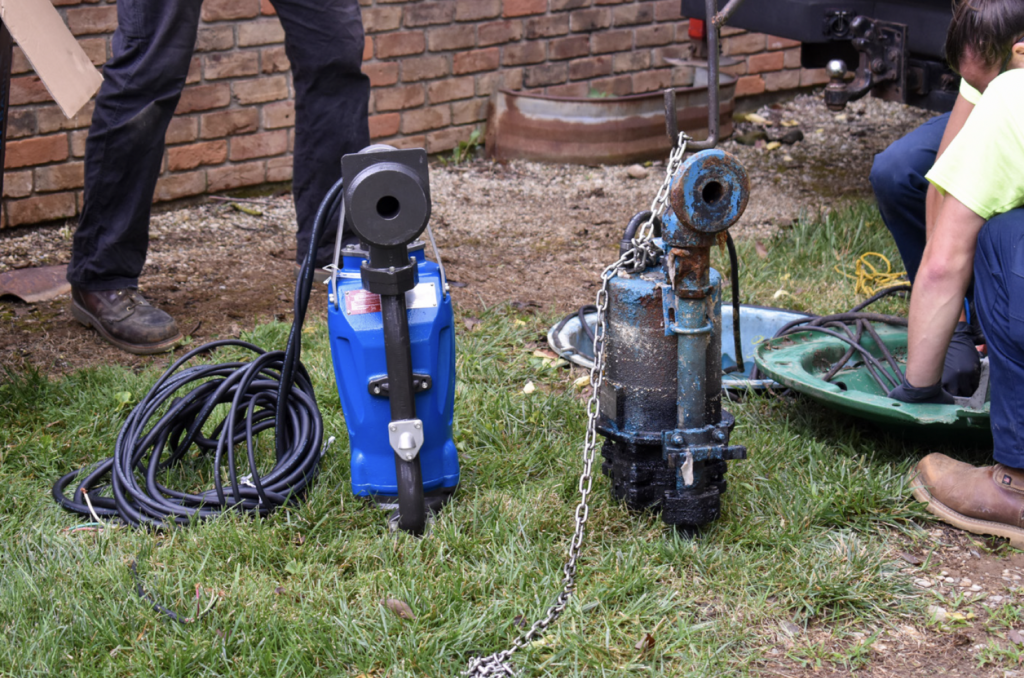 Two grinder pumps sitting side-by-side. Blue new grinder pump improves residential development. 